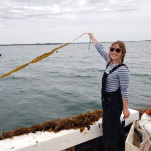 Elizabeth Ellenwood holding up kelp